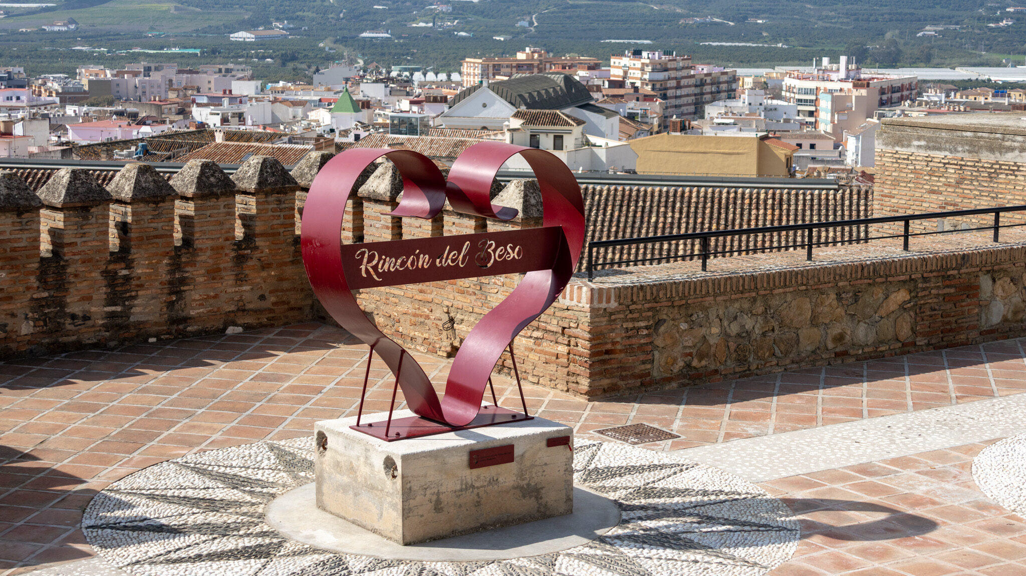 Kissing Corner Velez Malaga | Krista the Explorer Heart-shaped metal statue on top of medieval walls.