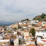 View of white village in Malaga with hilltop fortress.