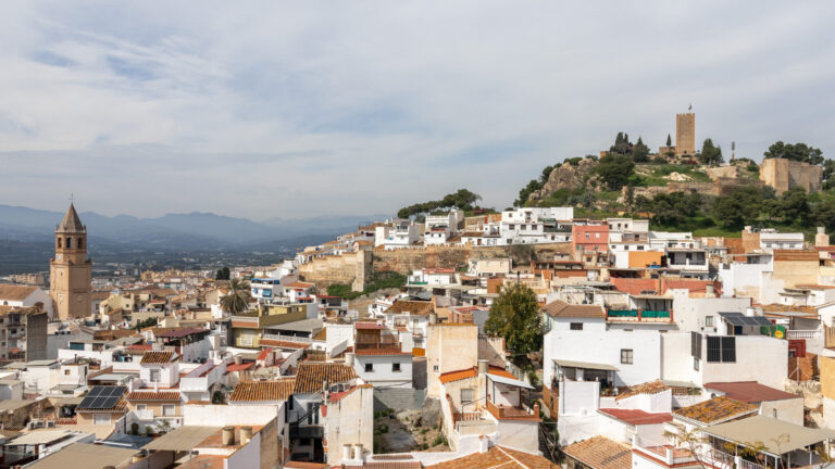View of white village in Malaga with hilltop fortress.