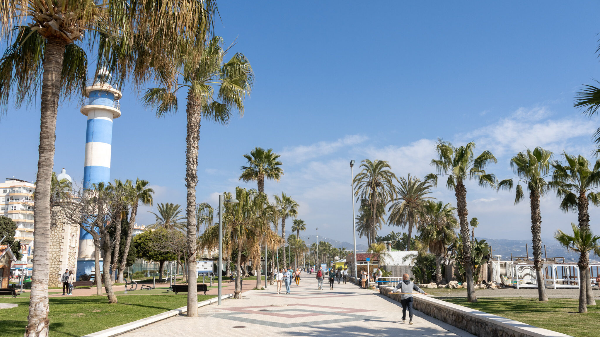 Promenade along the coast with blue striped tower.