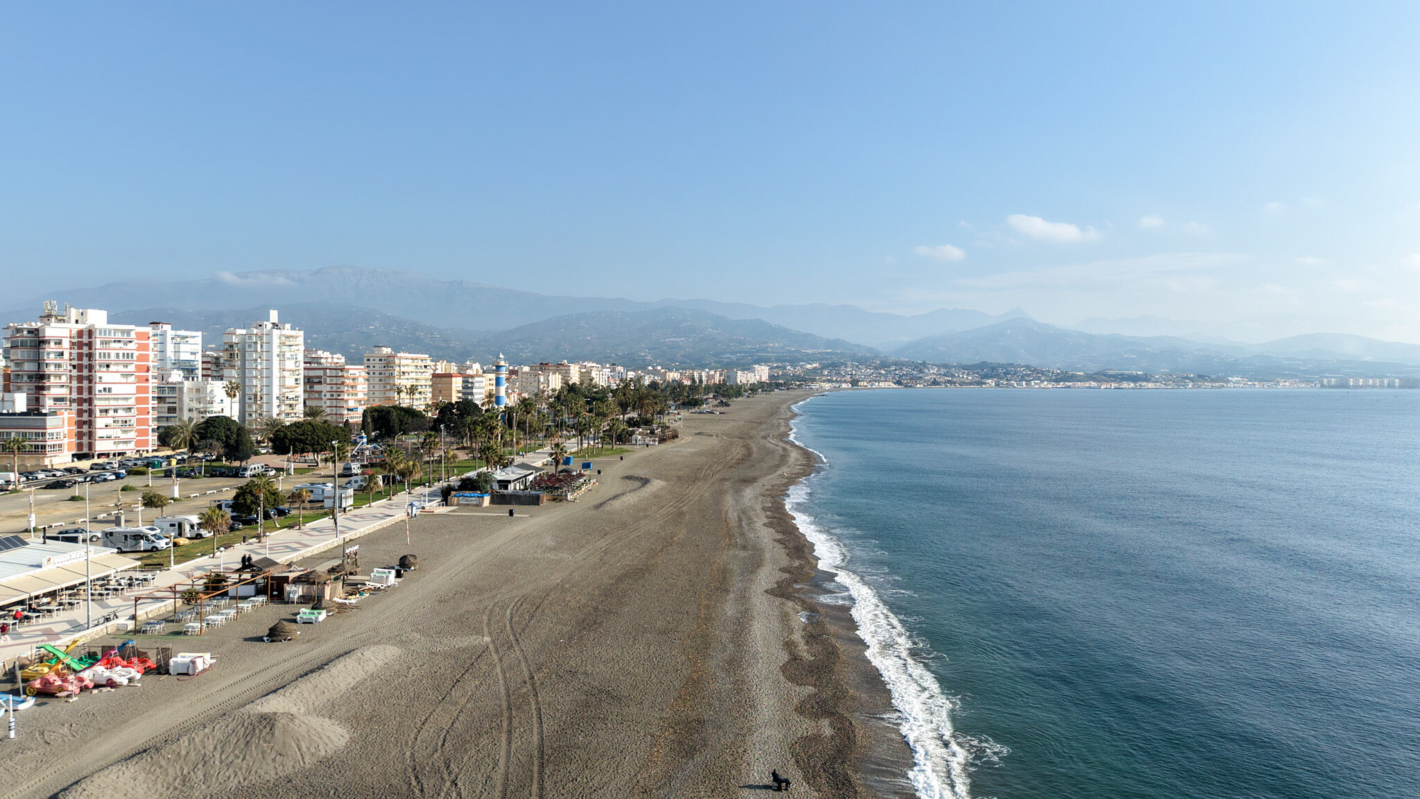 Aerial view of long stretch of beach in the morning.