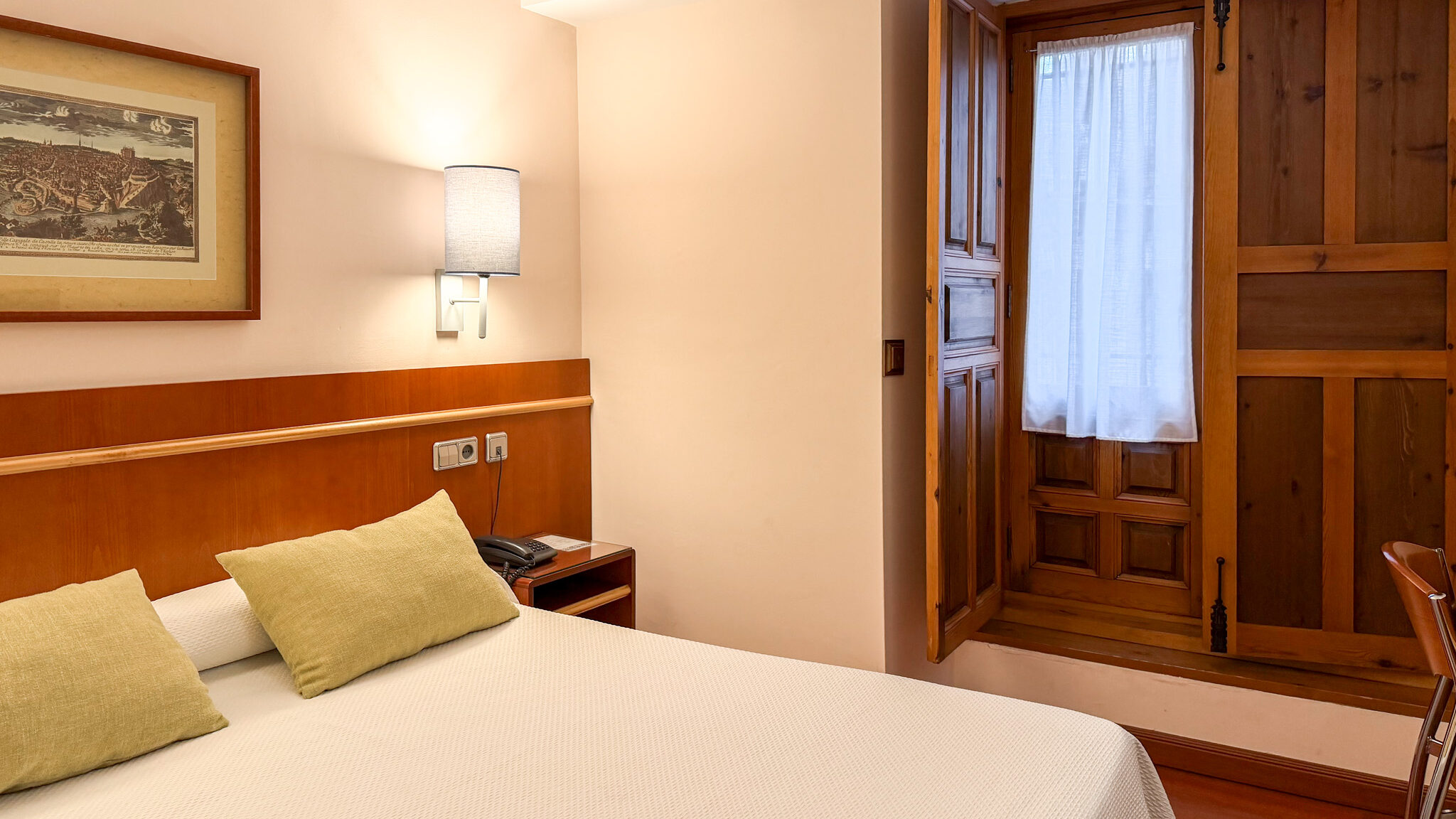 Double bed inside traditional Spanish hotel room.