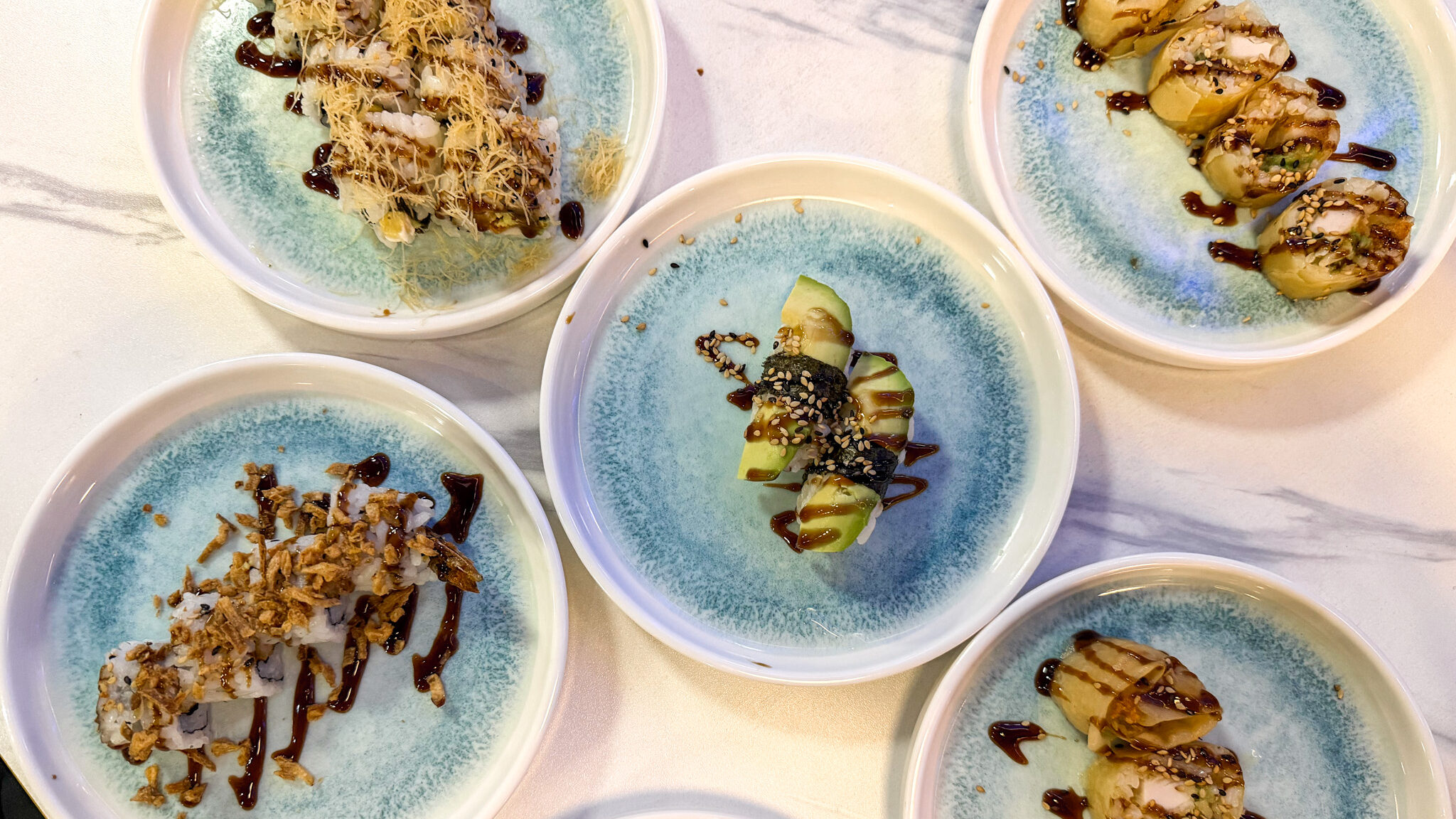 Sushi Yumi Zaragoza | Krista the Explorer Selection of sushi dishes laid out on plates.