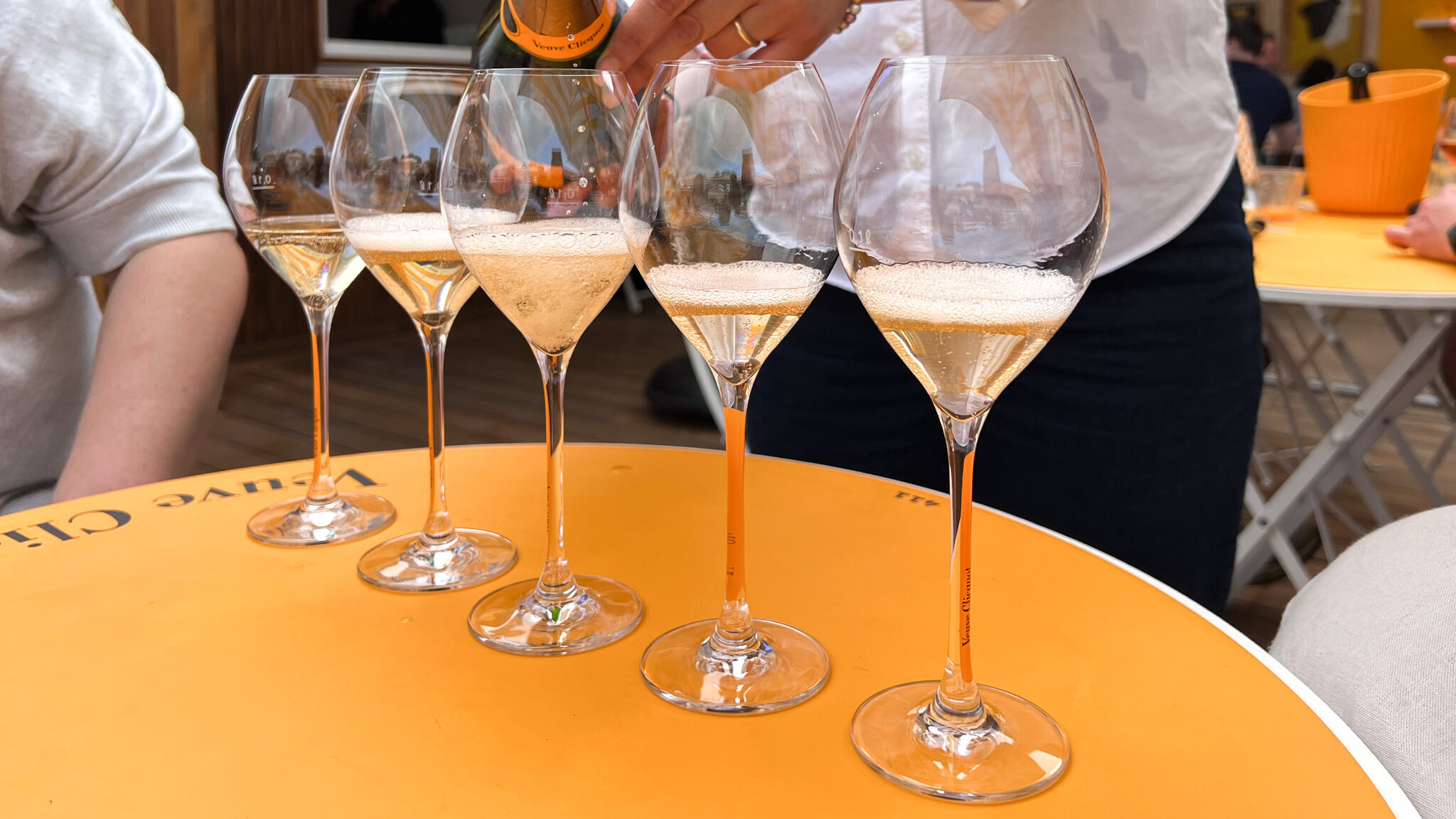 Row of glasses being poured with Champagne.