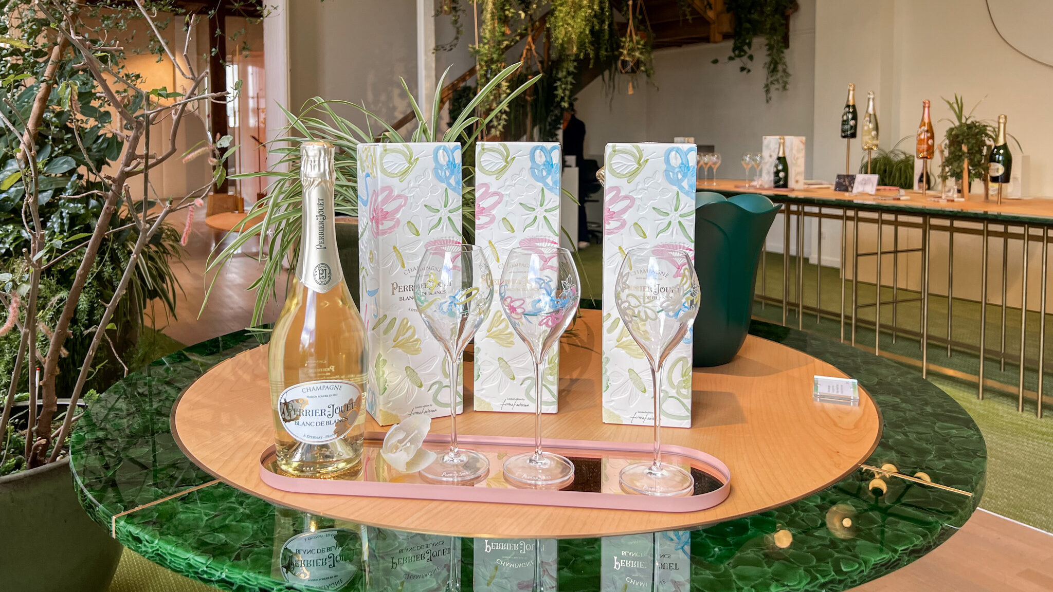 Champagne for sale in shop decorated with greenery. 