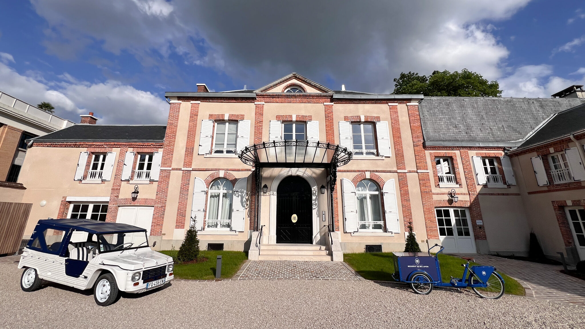 Historic champagne house with vintage car in front.