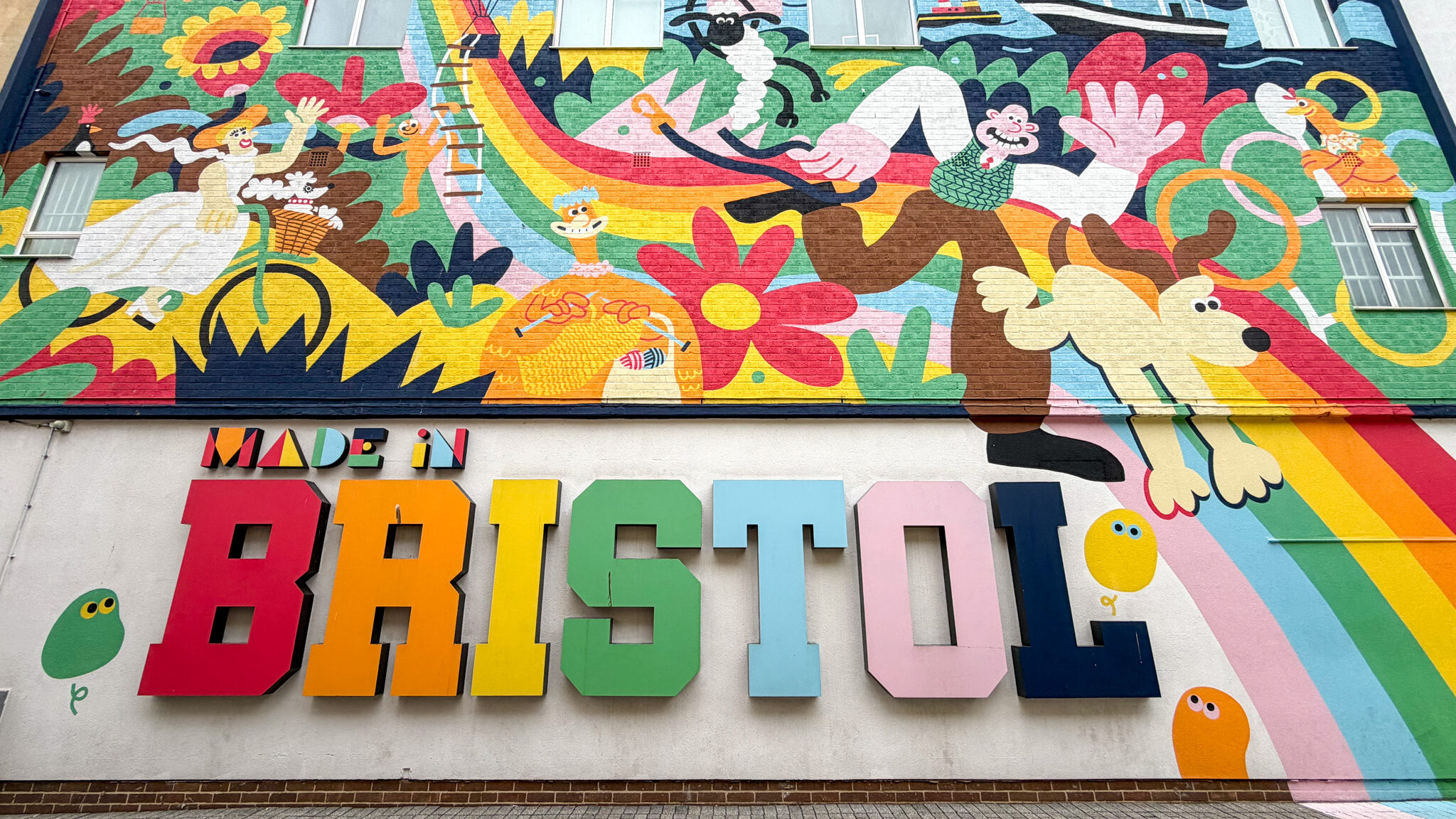 Bold, mural-covered wall, with a vibrant cartoon scene featuring balloons.