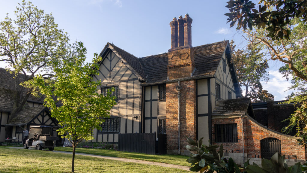 Tudor-style brick-and-timber house with a tall brick chimney.