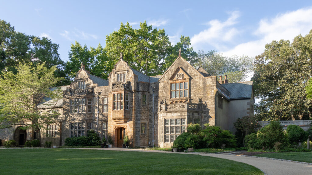 Historic stone mansion with ornate Gothic windows and decorative gables.