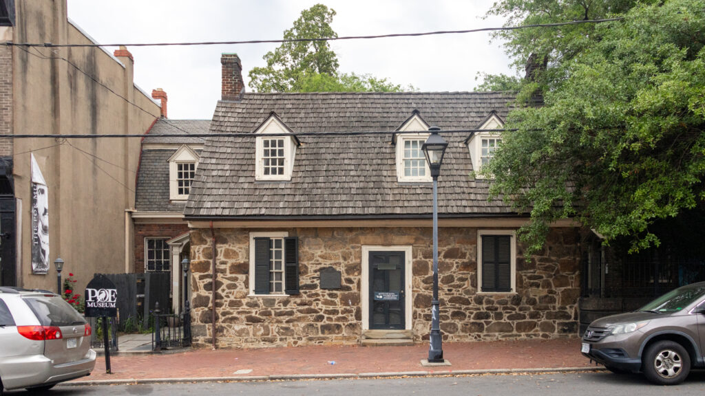 Historic stone building with a slate roof and three dormer windows.