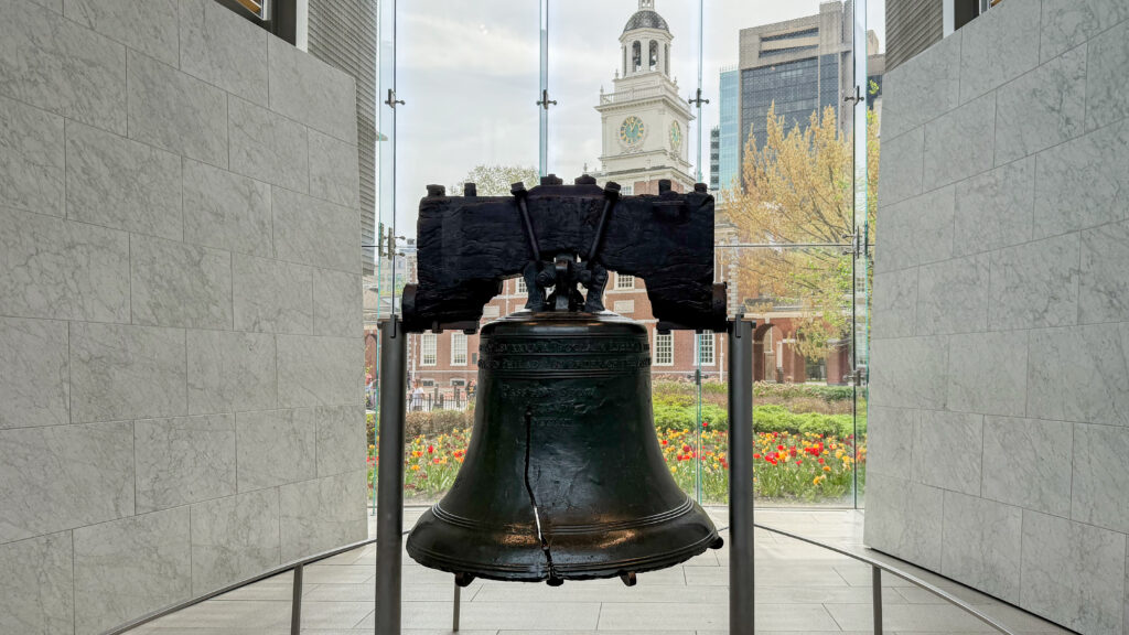 The Liberty Bell on a stand inside a marble-walled display room.