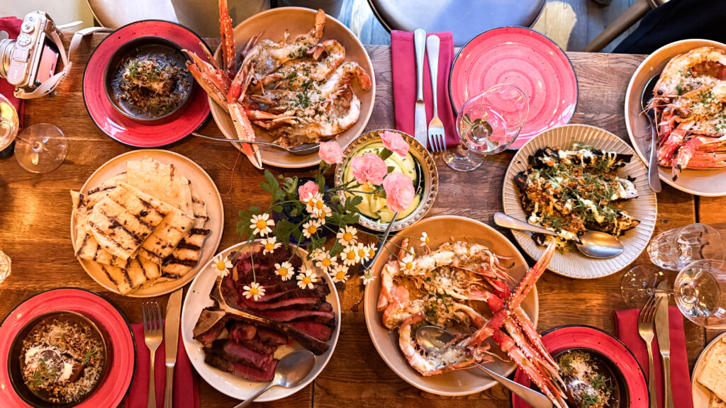 A wooden dining table loaded with a seafood feast.