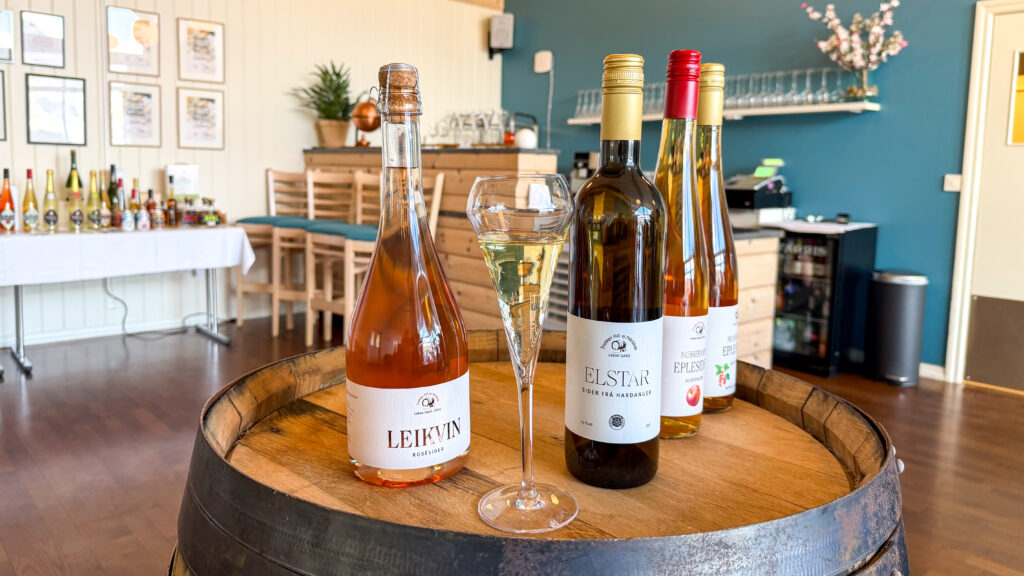 Wine bottles and glass set up on wooden barrel.