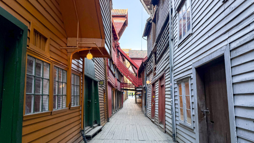 Narrow wooden alley lined with colourful buildings.