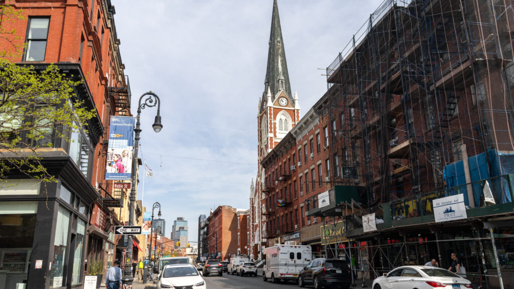 Greenpoint Brooklyn | Krista the Explorer City street with red brick buildings and a tall church spire in the center.