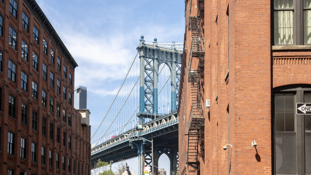 Washington Street Brooklyn | Krista the Explorer Bridge in the distance between two red brick buildings.