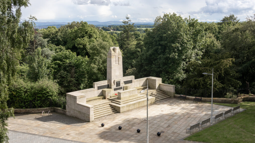 War Memorial | Krista the Explorer Stone memorial with tall obelisk and stepped plaza in a park.
