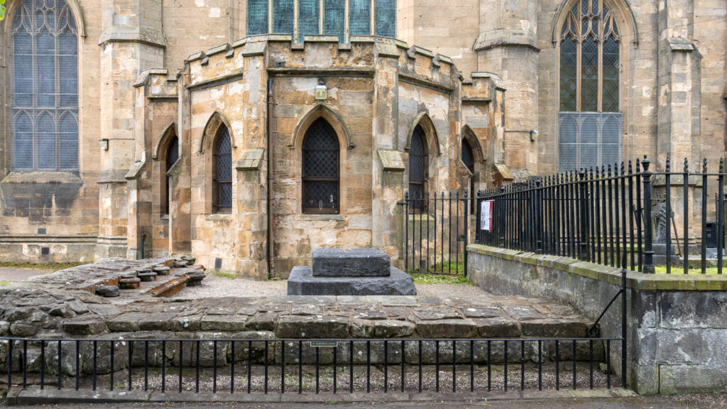 Tomb of Saint Margaret Dunfermline | Krista the Explorer Stone church exterior featuring arched windows with tomb in front.