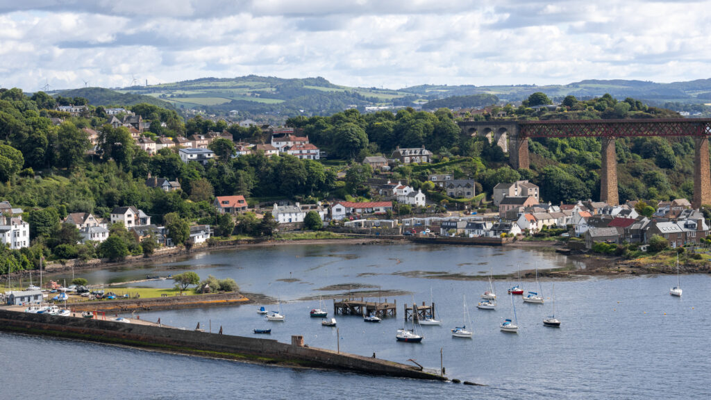 Aerial view of a coastal town with boats in a harbour.