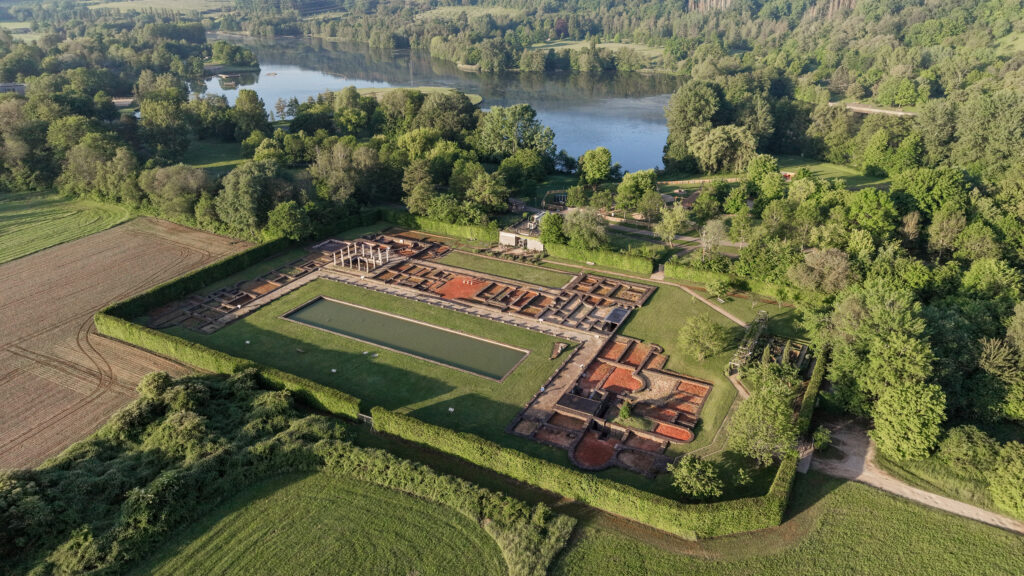 Ruins of ancient Roman villa next to small lake.