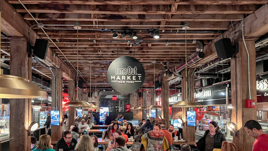 Time Out Market Brooklyn | Krista the Explorer Crowded Time Out Market New York interior with diners sitting at long tables.