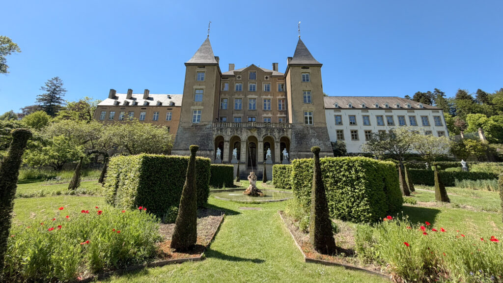 Front view of a historic château with two tall towers.