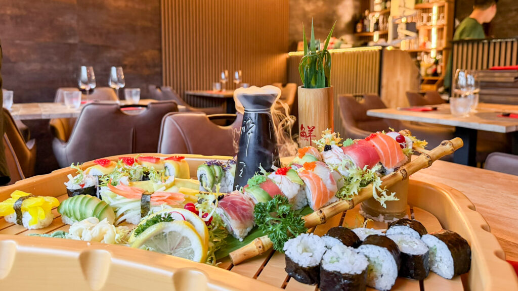 Assorted sushi platter with nigiri and rolls on a wooden table.