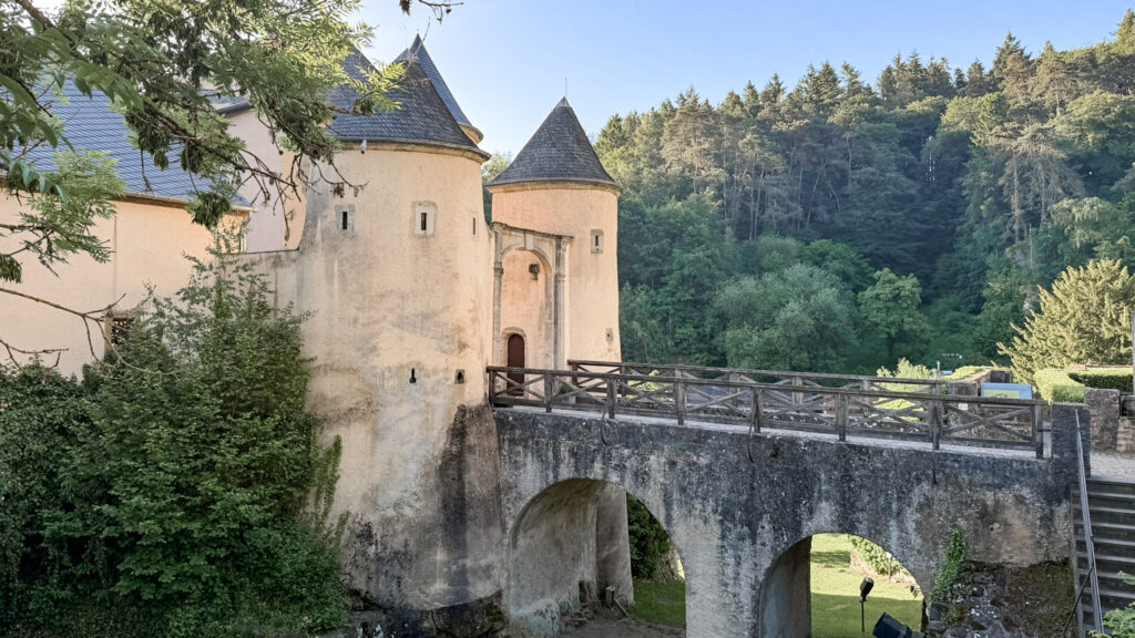 Beige castle walls with rounded towers and conical roofs.