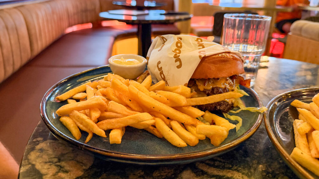 Urban Bar & Restaurant Luxembourg | Krista the Explorer Plate of a cheeseburger with melted cheese, wrapped in paper.
