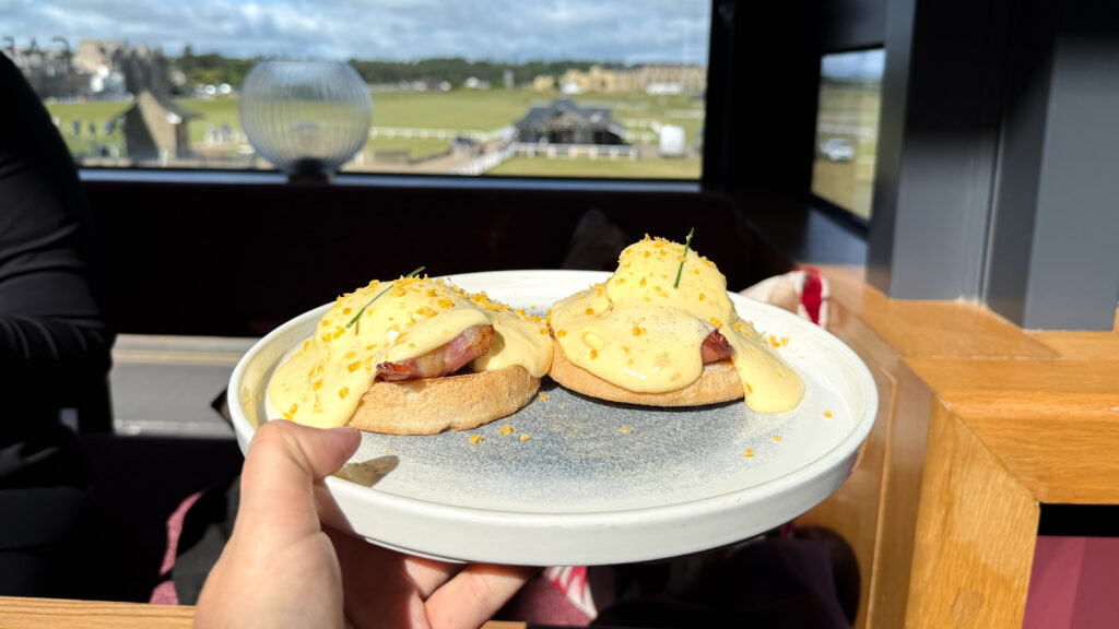 Two eggs Benedict with hollandaise and bacon on toasted English muffins.