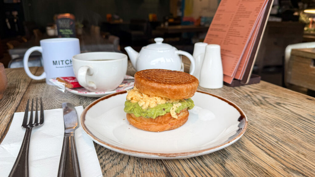 Round sandwich croissant with avocado and eggs.
