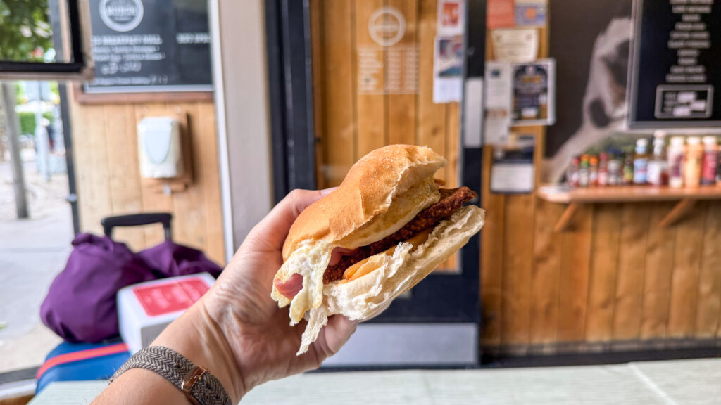 Breakfast roll with bacon and egg inside cafe.