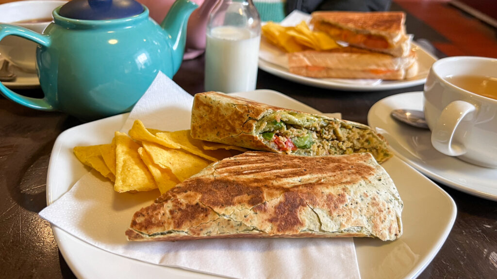 Quesadilla-style wrap sliced in half on a plate with tortilla chips.