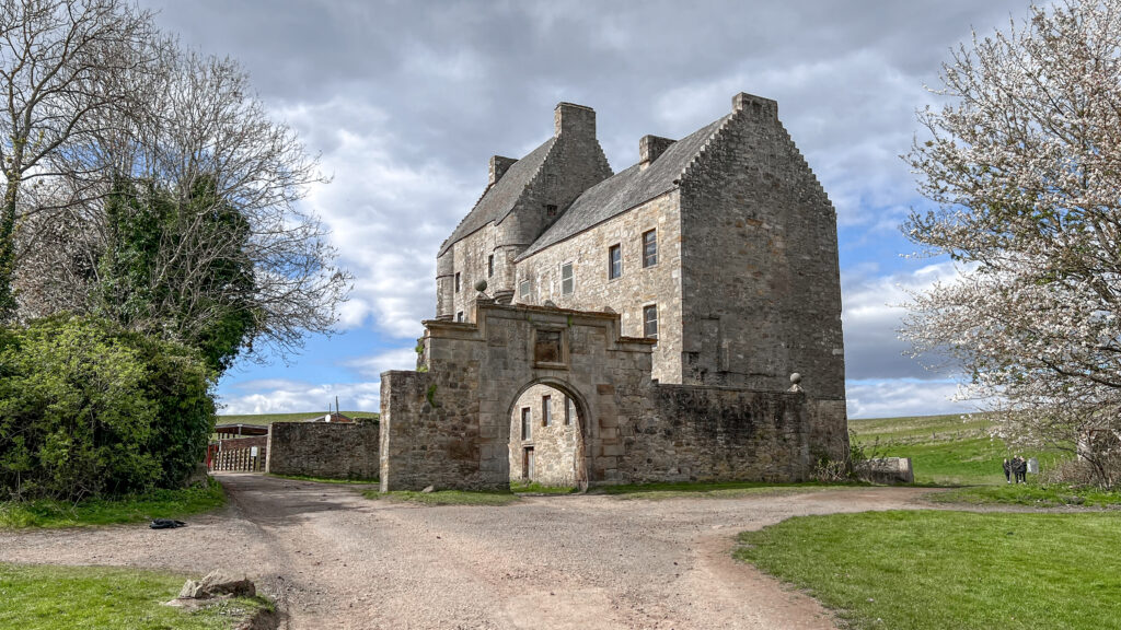 Stone castle ruin with arched gateway in Scotland.