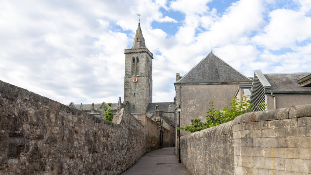 Narrow pedestrian street between medieval stone walls.