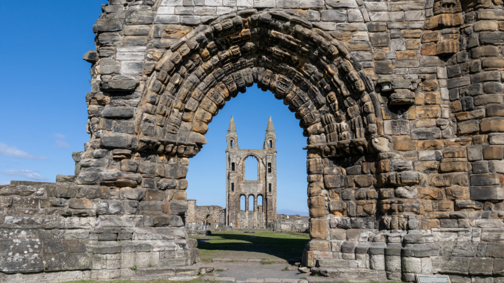 Stone archway entrance to ruins of medieval cathedral.