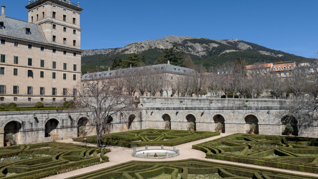 Stone monastery with elaborate gardens at the back.