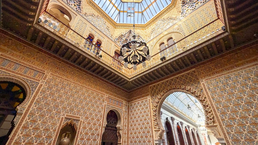 Real Casino de Murcia | Krista the Explorer Ornate Moorish-style interior with gold-patterned walls, arches, and a central hanging chandelier.