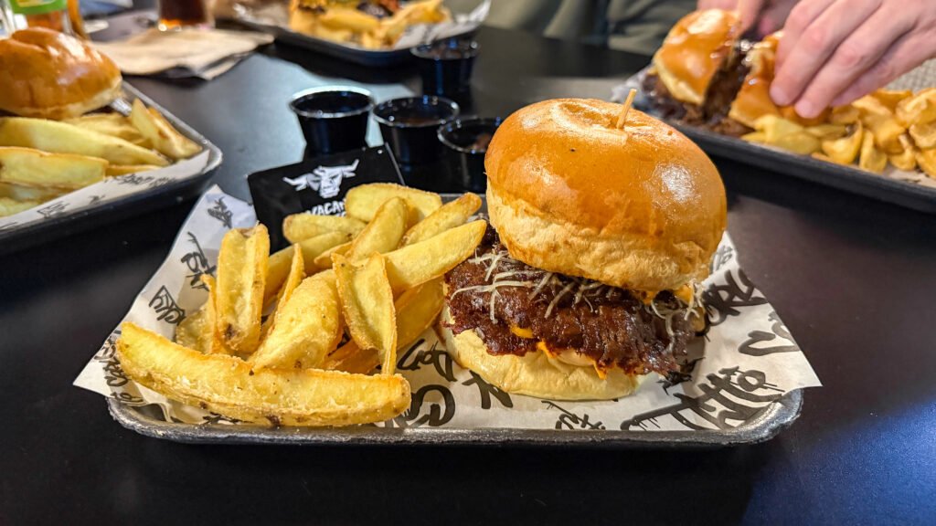 Vacania Burger Murcia | Krista the Explorer Burger topped with melted cheese and crispy bacon, served with thick-cut fries.