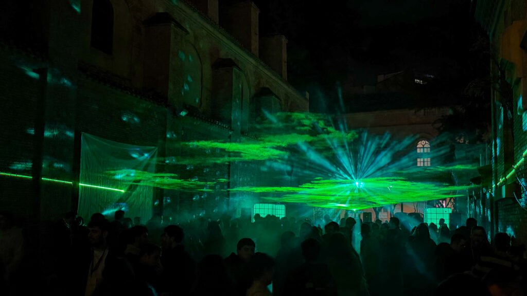 Nightclub Murcia | Krista the Explorer Crowd of people dancing in a dark brick-walled venue with green laser beams.