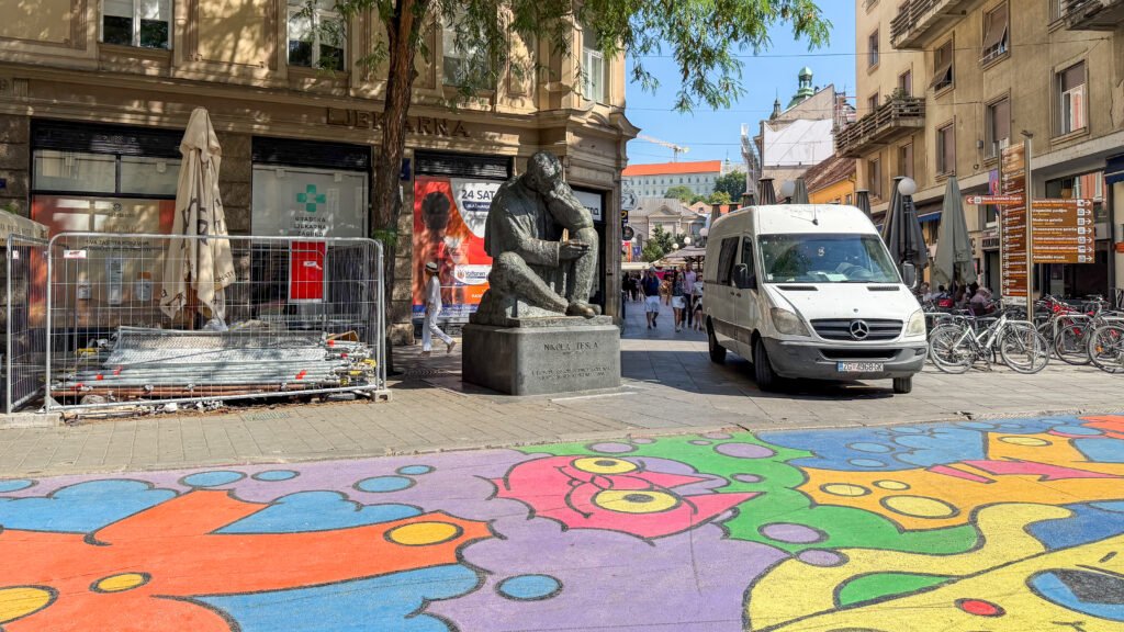 Colourful mural painted on ground of pedestrian street.