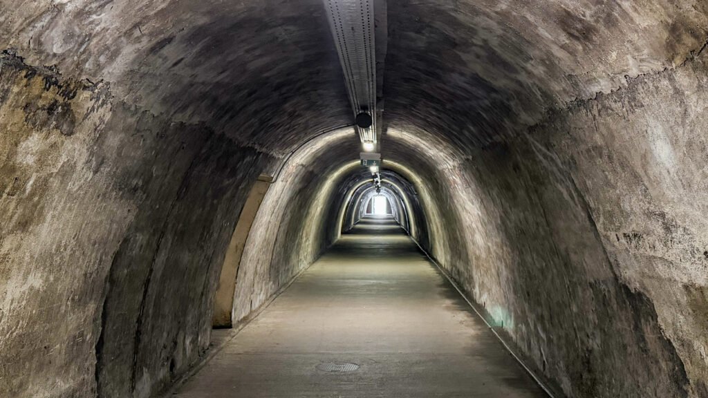 Gric Tunnels Zagreb | Krista the Explorer Long underground stone tunnel with arched walls and overhead lights.
