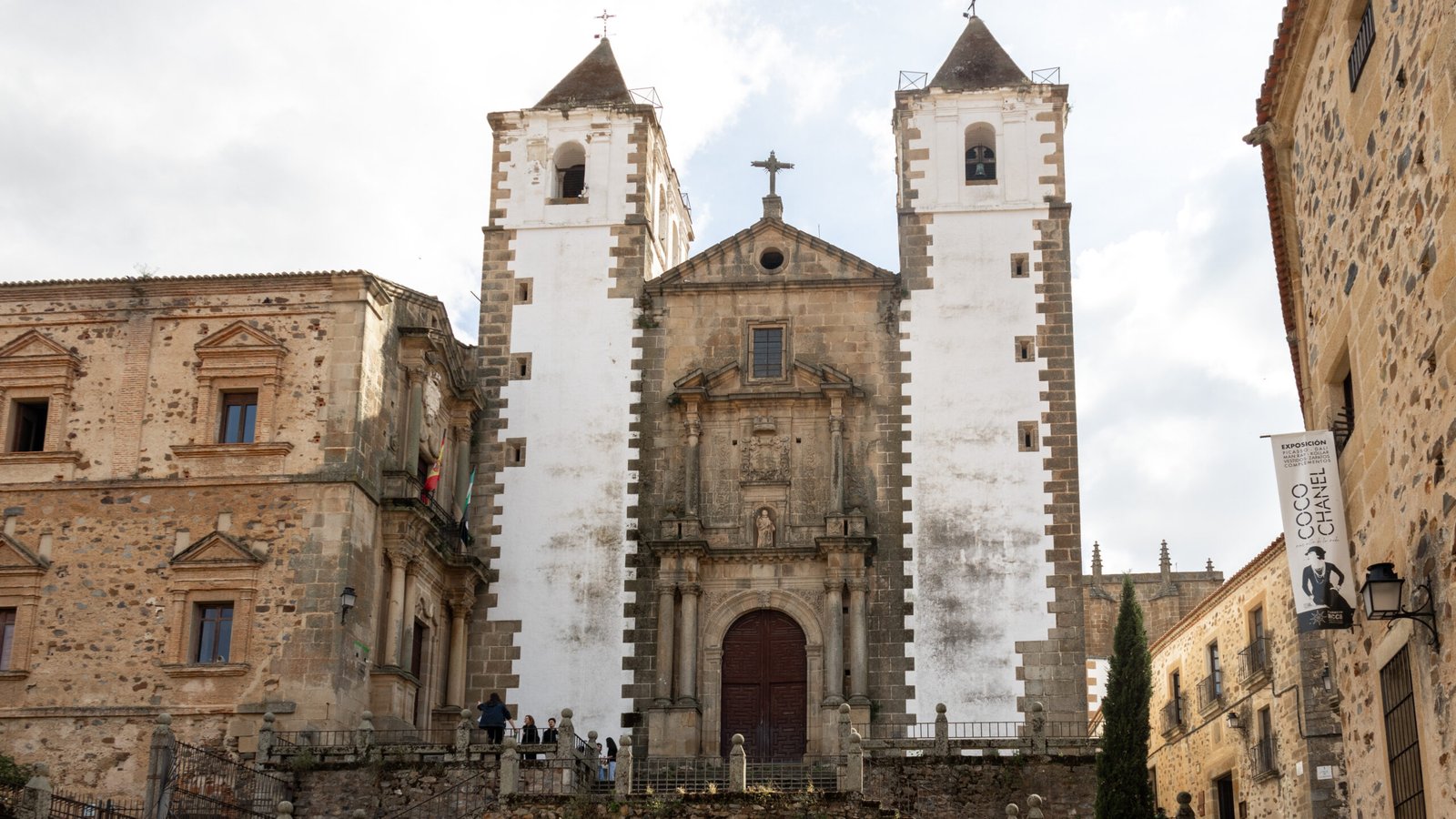 Historic stone church with two white painted towers.