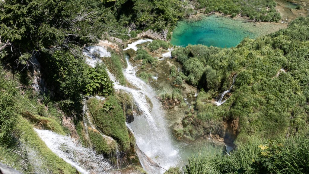 Plitvice Lakes | Krista the Explorer Aerial view of a turquoise pool fed by a cascading waterfall.