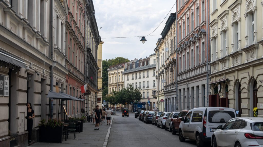 Kazimierz District Krakow | Krista the Explorer Narrow city street in a historic district with tall ornate buildings on both sides.