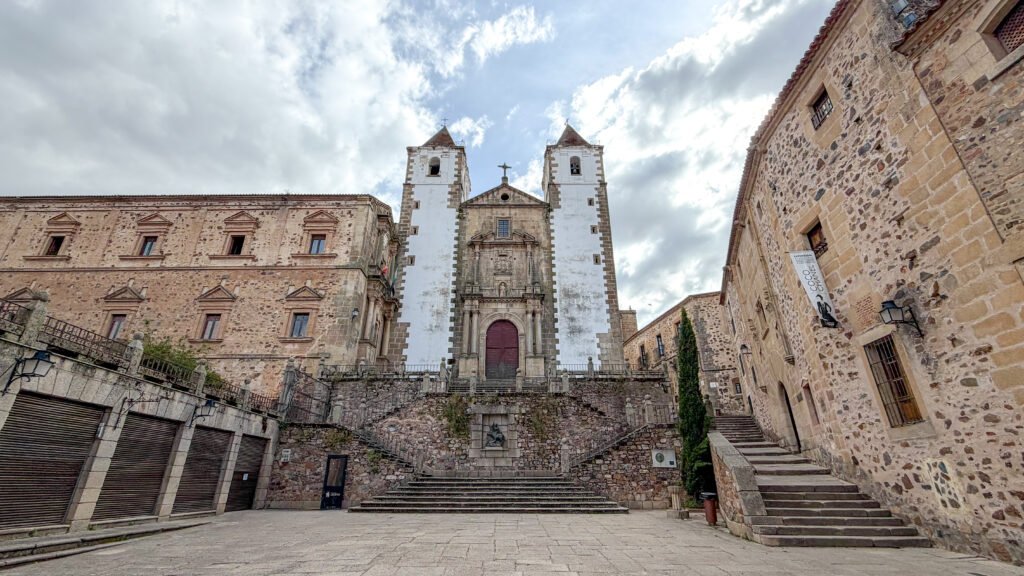 Plaza de San Jorge Caceres | Krista the Explorer Facade of a historic church with two white towers flanking a central doorway.