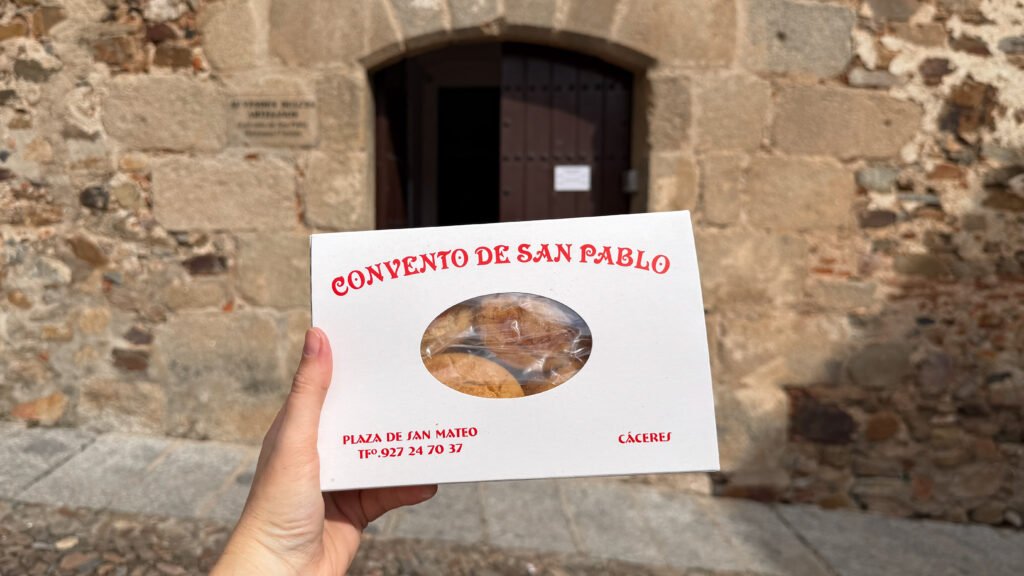 Nuns Cáceres | Krista the Explorer Box of Convento de San Pablo pastries held in front of an old stone wall.