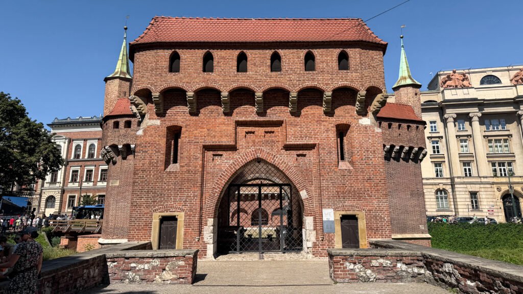 Kraków Barbican | Krista the Explorer Historic brick gatehouse with rounded arches and two towers.