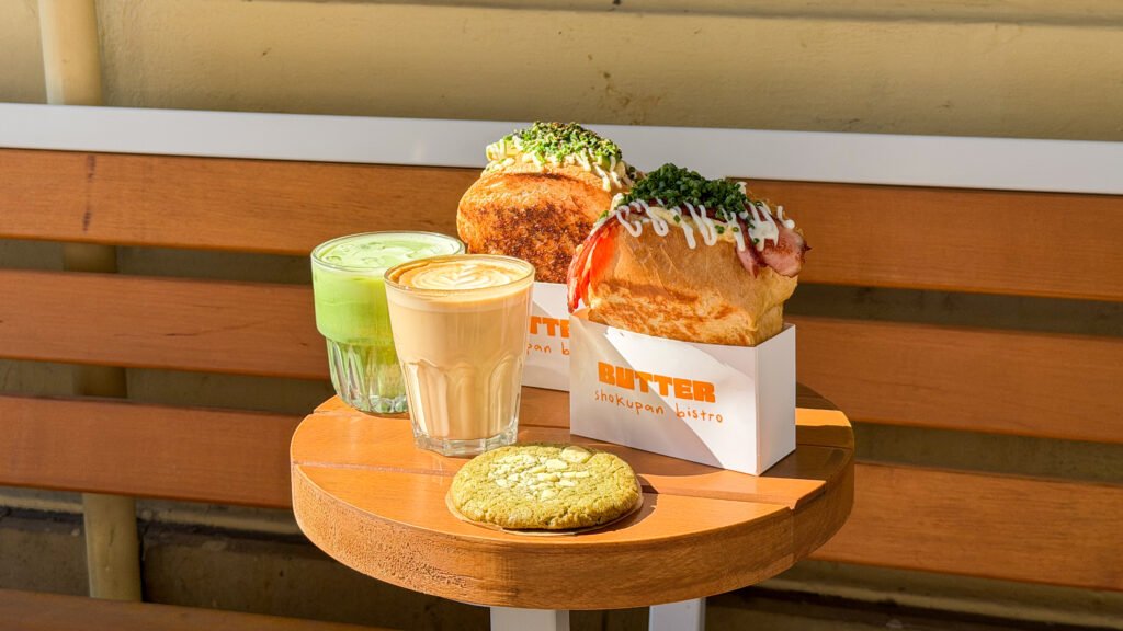 Butter Cafe Krakow | Krista the Explorer Two loaded buns with toppings sit on a white carrier box at a café table.