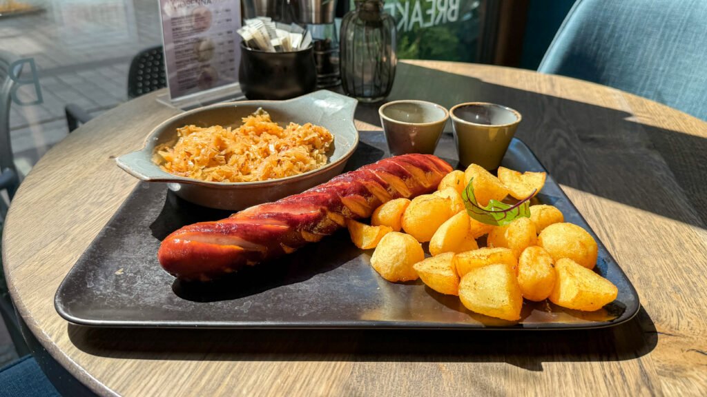DESTINO Brunch Café Krakow | Krista the Explorer Black plate with Polish sausage, potatoes, and cabbage.